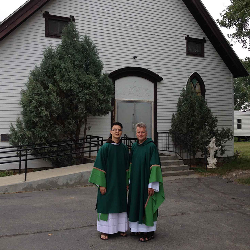 Capuchin friars Tien Dinh and Mark Joseph Costello outside St. Francis Xavier Mission Church in Montana